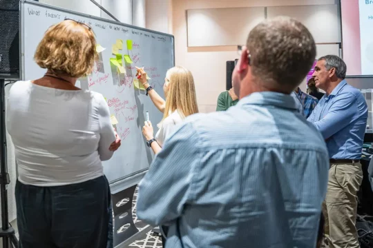 People gathered round a white board collaborating
